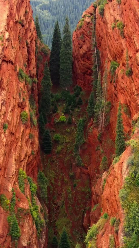 Close view of narrow chasm between Seven Bulls red rock pillars in Kyrgyzstan Stock Footage 344651557