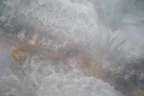 Close-up view of a natural marble or onyx stone slab with cloudy, veined Stock Photos