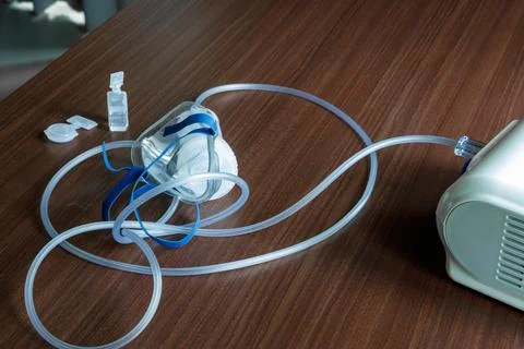 A close-up view of a nebulizer machine connected to a face mask and a small.. Stock Photos