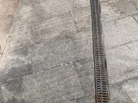 Close-up view of a neutral-toned, tiled path with drainage system outdoor set 写真素材