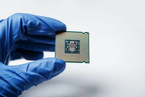 Close-up view on a new semiconductor microchip in gloved hand of computer Foto stock