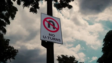 Close up view of no u-turn sign against blue rainy cloudy sky. Stock Footage 280387854