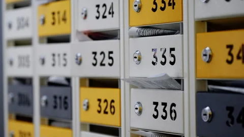 Close-up view of numbered apartment mailboxes with yellow and white doors Vídeos de archivo 317566957