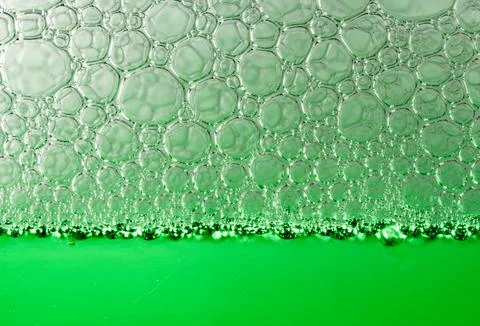 Close-up view of numerous green bubbles forming a textured surface on a liqui Foto stock