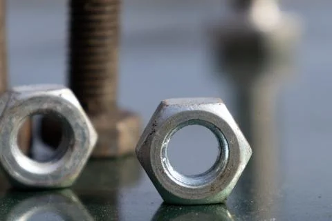 Close View of Nuts and Bolts on a Flat Surface in a Workshop Setting During.. Foto stock