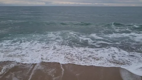 Close View of Ocean Waves Crashing Gently on Sandy Shore Stock Footage 320253736