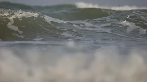 Close view of ocean waves forming foam as they reach the beach, recorded in.. Stock Footage 320517700