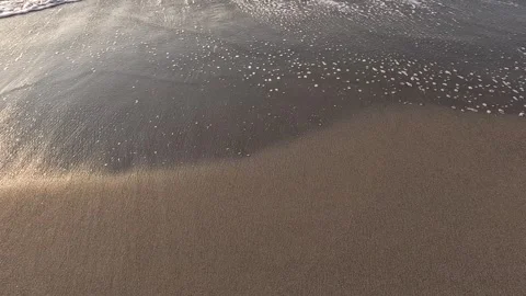 Close up view of ocean waves rolling onto a sandy beach Stock Footage 297081896
