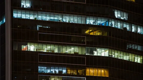 Close up view to office windows of skyscraper in downtown at evening, working Stock Footage 112023638