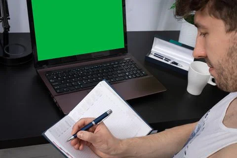 A close-up view of an office worker writing notes on a calendar about the next Foto stock