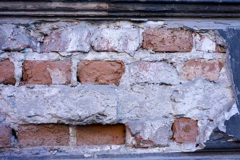 A close-up view of an old brick wall showing different textures. The bricks h Stock Photos
