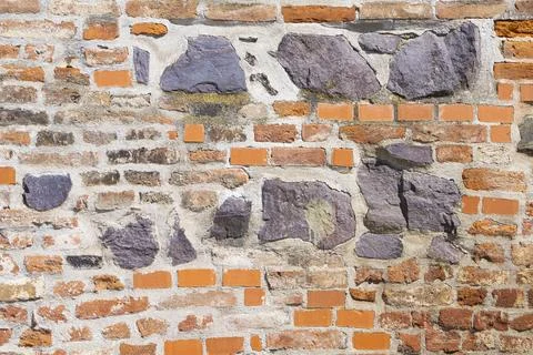 A close-up view of an old brick wall shows a textured pattern of orange bri.. Stock Photos