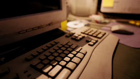 A close up view of an old computer keyboard and monitor setup in an office Stock Footage 293437313