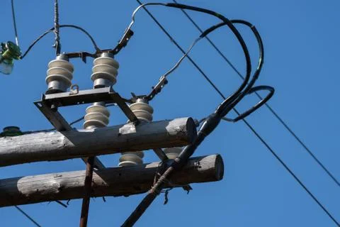 Close-up view of old electricity post with wires on insulators in sunny day Stock Photos