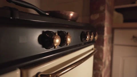 Close up view of old kitchen fire knobs oven with metal pan on top. light 動画素材 148713987