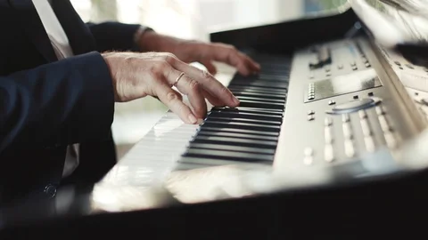 Close up view of an old man pianist playing the fortepiano in a deserted Stock Footage 98246641