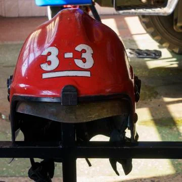 Close-up view of old red fire helmet. 911 concept. Stock Photos