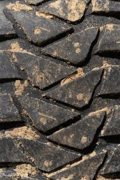 Close-up view of old used rubber mud terrain tire worn wear-resistant tread Stock Photos