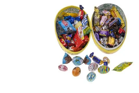 Close up view of an open gift Easter egg with candies inside isolated Stock Photos