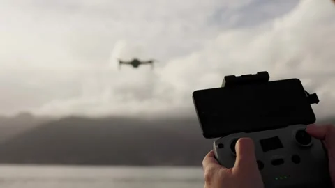 In a close-up view, the operator grips the control panel of a quadcopter drone Stock Footage 307239779