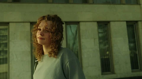 Close-up view of a optimistic young caucasian woman with curly hair standing Stock Footage 271305616
