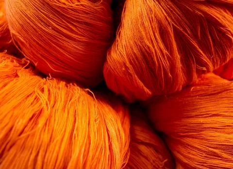 Close view of the orange color thread yarns used in textile industry Stock Photos