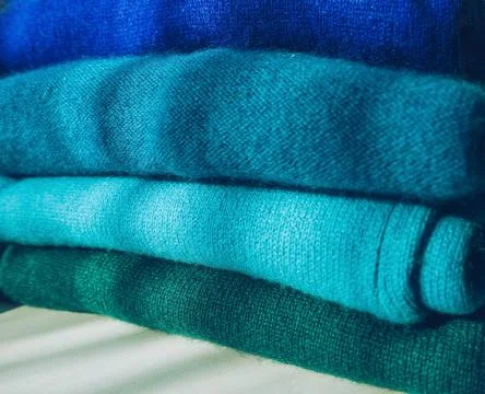 Close up view of organized stack of blue to green gradient cachemire clothes Stock Photos