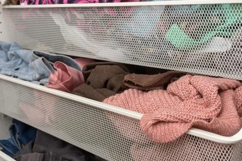 Close view of overstuffed wardrobe drawer with knitwear and casual clothes Stock Photos
