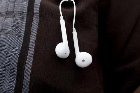 Close up view of a pair of classic white wired earphones hanging out from t.. Stock Photos