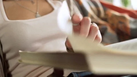 Close up view of paper book in hands of latin young woman who read it, sitting Video stock 73871761