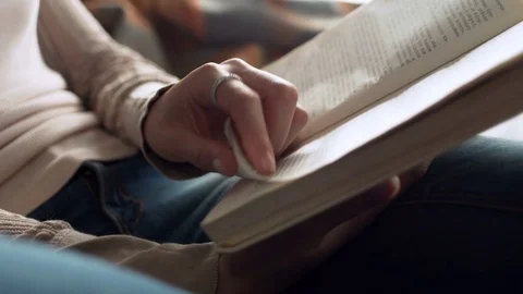 Close up view of paper book in hands of latin young woman who read it, sitting Видео 73874023