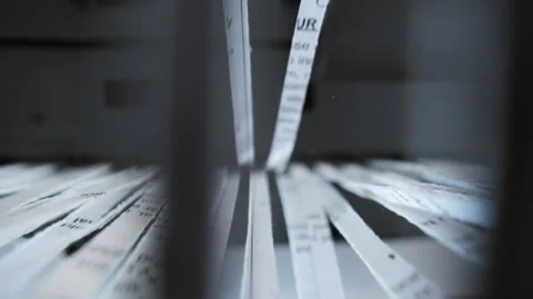 A close up view of a paper shredder cutting a sheet of office paper, document Stock Footage 297086806