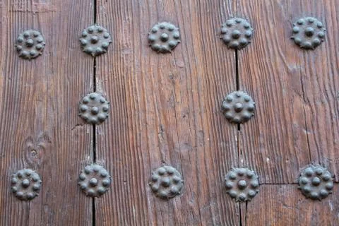 A close-up view to a part of old brown wooden door with metal rivets. Foto stock