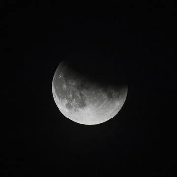 Close up view of a partial lunar eclipse in the black night sky in July 2019 Stock Photos