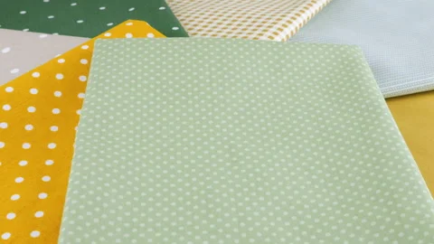 Close-up view of the pastel-colored cotton fabric strips in polka dot and check  Stock Footage 293889618