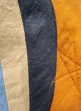 Close up view of a patchwork quilt with stitched strips of light blue, beig.. Stock Photos