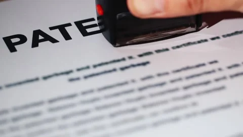 A close up view of a patent document being approved with a red stamp, signi.. Stock Footage 334646089