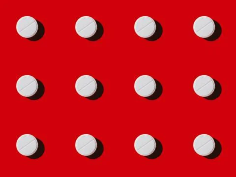 Close-up view of pattern made from white vitamins on red Stock Photos