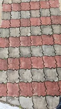 A close-up view of a paved surface made up of interlocking red and gray tiles Stock Photos