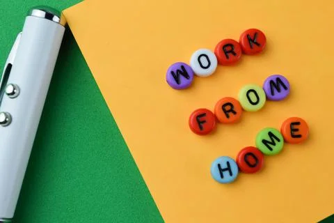Close up view of pen, memo note and alphabet beads with text WORK FROM HOME Foto stock