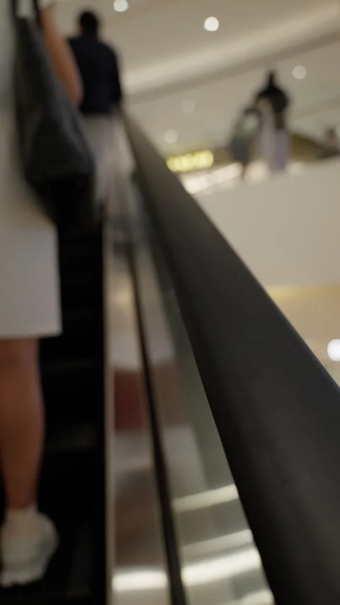 Close-up view of people ascending on an escalator within a modern indoor Video stock 310489357