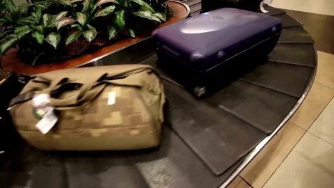 Close-up view of people receiving baggage from conveyor belt at airport after Stock Footage 256744983