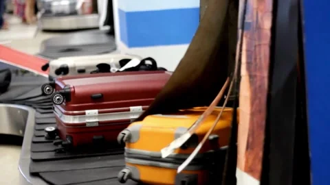 Close-up view of people receiving baggage from conveyor belt at airport after Stock Footage 256745435