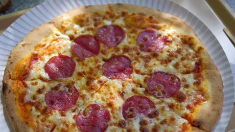 A close-up view of a pepperoni pizza with melted cheese and crispy crust, t.. Stock Footage 295195951