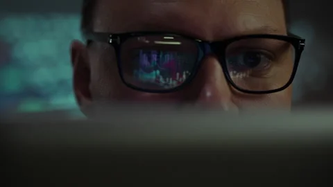 Close view of a person analyzing data on a computer screen in a darkened env Stock Footage 293706505