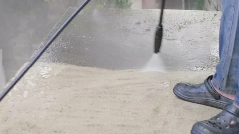 Close up view person with high pressure jet gun spray water to ground cleanin Stock Footage 157007350