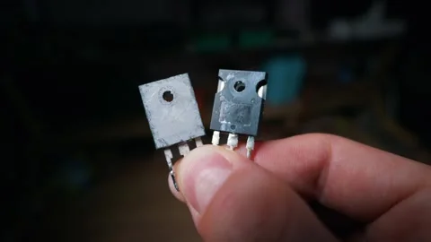 Close Up View of Person Holding Two High Power Electronic Transistors in Hand Stock Footage 339364577