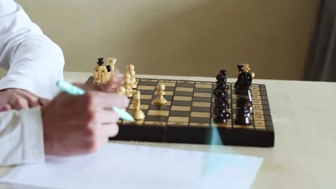 Close-up view of a person playing chess on a wooden board, moving a pawn forward Stock Footage 278900169