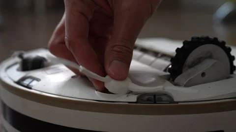 Close-up view of person replacing old worn side brush on robotic vacuum cleaner. Stock-Footage 342754887