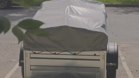 Close up view of a person securing a gray waterproof cover over a metal utility Stock Footage 341493608